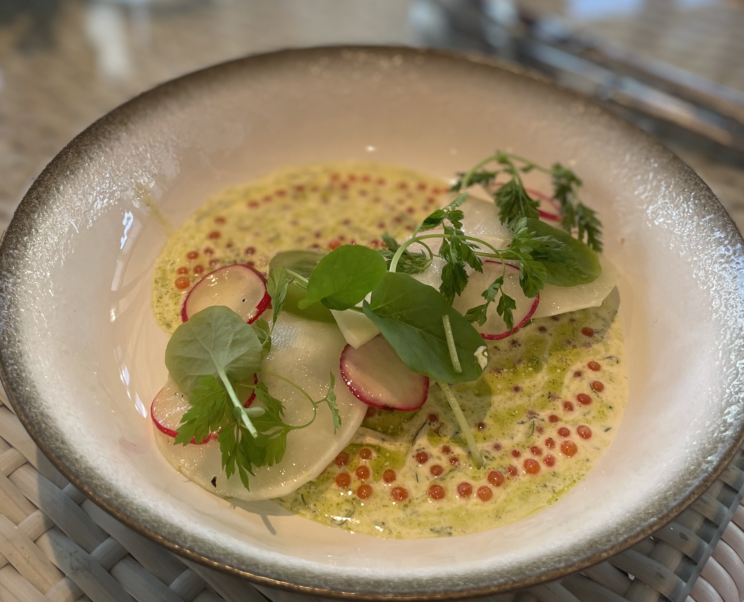 I restauranten vår serveres nydelige retter, delikat tilberedt av våre dyktige kokker. -En kokk heller saus over kjøtt og grønnsaker på en ferdig tilberedt rett med pommes frites i liten metallbøtte -