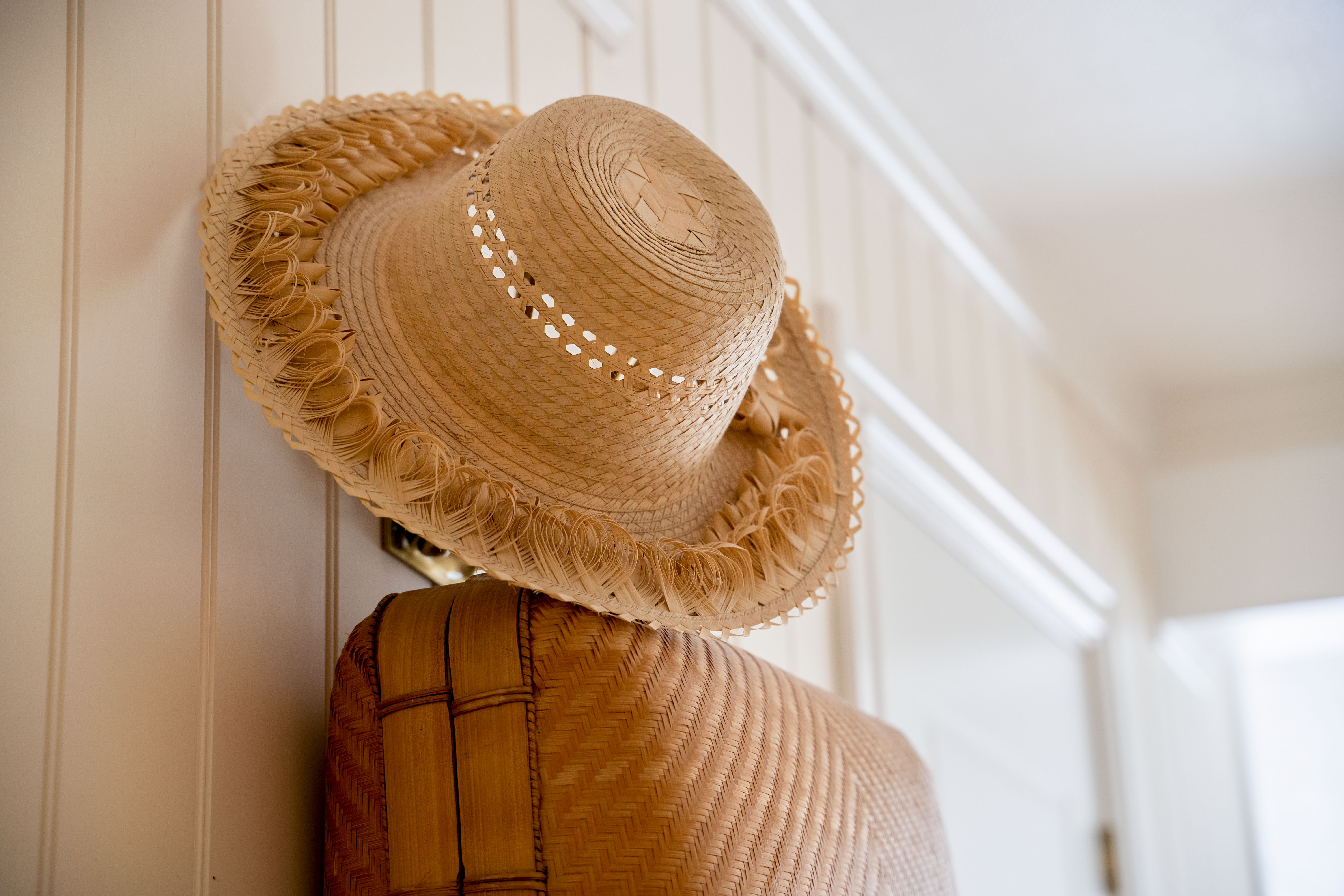 Del av fasaden og skiltet til Badehotellet, med busker i forkant