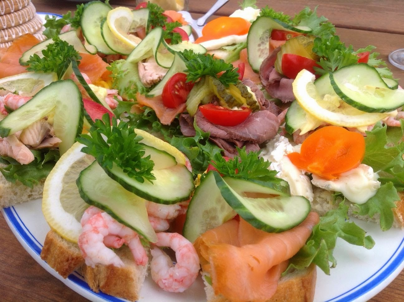 -En kokk heller saus over kjøtt og grønnsaker på en ferdig tilberedt rett med pommes frites i liten metallbøtte -